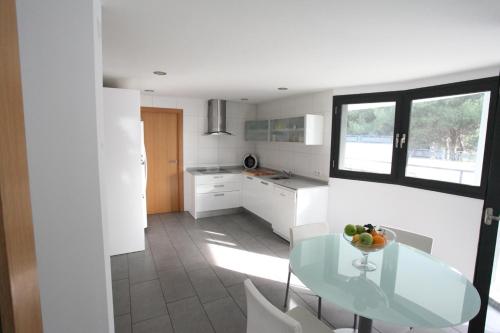 a kitchen with a glass table and white cabinets at Can Pastilla II in Can Pastilla