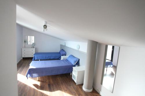 a bedroom with two beds in a white room at Can Pastilla II in Can Pastilla