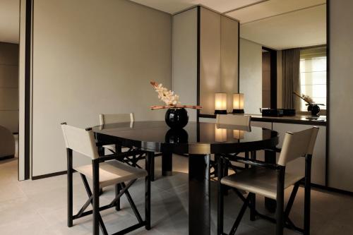a dining room with a black table and chairs at Armani Hotel Milano in Milan