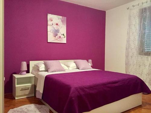 purpurowa sypialnia z łóżkiem z fioletową ścianą w obiekcie Kuća za odmor "Barbenjak" w mieście Vir