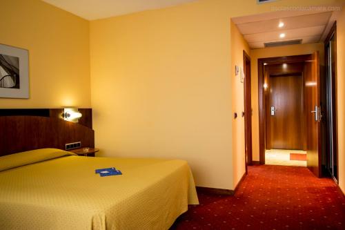 a hotel room with a bed and a hallway at Hotel Silvota in Lugo de Llanera