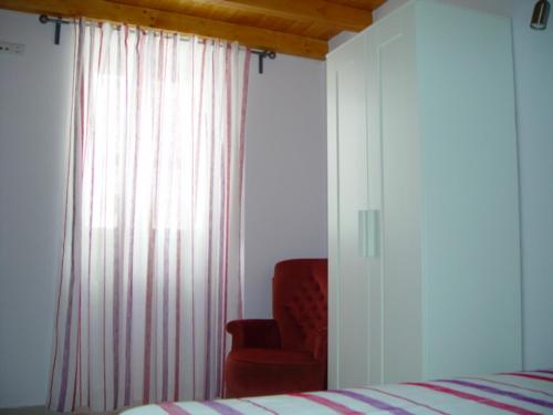 ラゴスにあるLovely Houseのベッドルーム1室(ベッド1台、窓際の赤い椅子付)