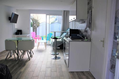 uma cozinha com um balcão, uma mesa e cadeiras em La cabine de plage em Batz-sur-Mer