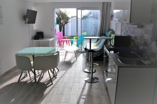 a kitchen with chairs and a table and a counter at La cabine de plage in Batz-sur-Mer
