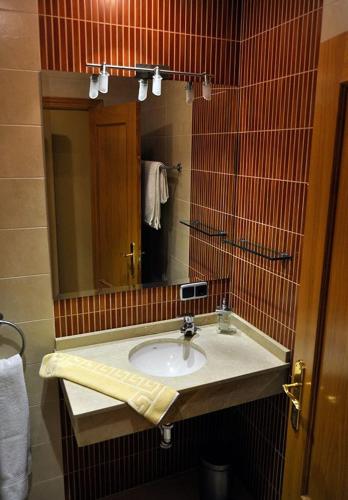 a bathroom with a sink and a mirror at Hostal Puerta del Valle in Valladolid