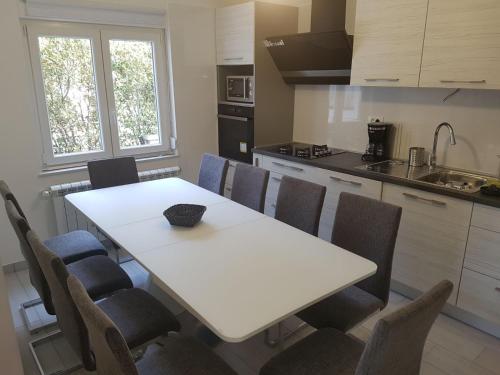 a kitchen with a white table and chairs at App Sandra 3 bedrooms on 112m2 Kostrena in Šodići