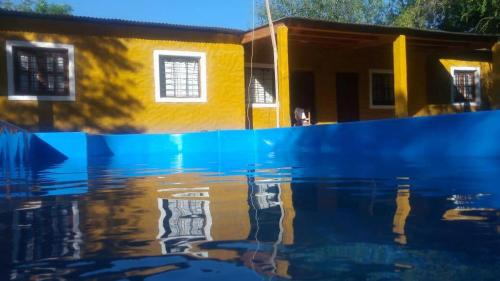 un reflet d'une maison dans un bassin d'eau dans l'établissement Cabañas del Dique, à Termas de Río Hondo