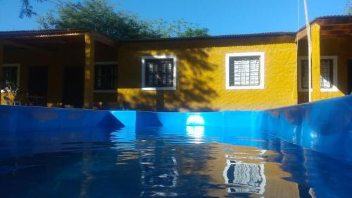 una piscina de agua frente a una casa en Cabañas del Dique en Termas de Río Hondo