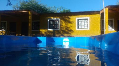 a pool of water in front of a house at Cabañas del Dique in Termas de Río Hondo