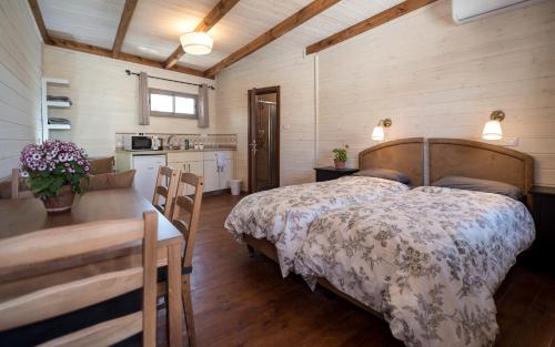 a bedroom with a bed and a table and a kitchen at Myrtle the Turtle Guesthouse in Safed