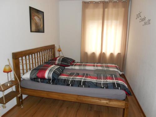 a bedroom with a bed with a wooden bed frame at Apartments Nikol - Ludwigshafen in Ludwigshafen am Rhein