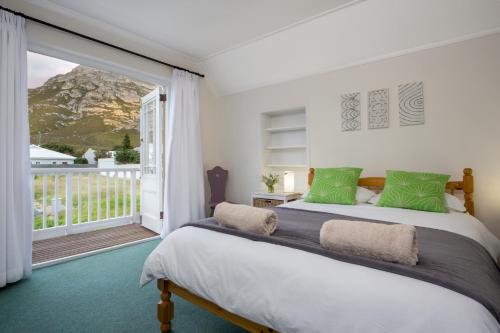 a bedroom with a bed and a large window at Stone Chimney Cottage in Hermanus