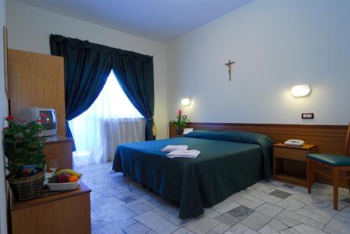 a bedroom with a blue bed and a window at Hotel Delle Rose in Cascia