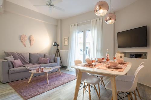 una sala de estar con una mesa y un sofá en "SunBow Earth"- Boutique new Apt in Dowtown Athens, en Atenas