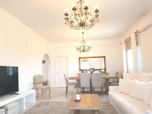 a living room with a chandelier and a table at Artemis Sunny Villa in Antiparos