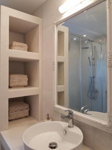 a white bathroom with a sink and a shower at Artemis Sunny Villa in Antiparos