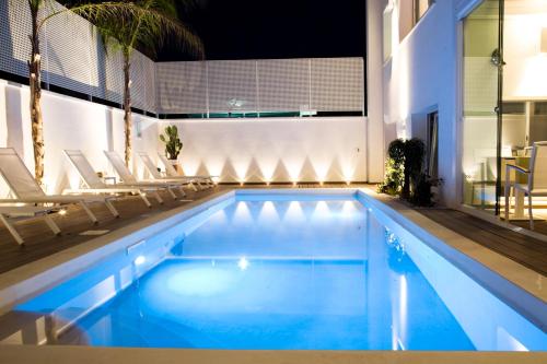 a swimming pool with chairs and a swimming pool at La Dimora delle Fate Luxury & SPA in Miggiano