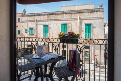 a table and chairs on a balcony with a building at Palazzo Rattazzi in Monopoli