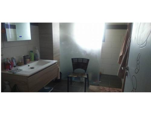 La salle de bains est pourvue d'un lavabo et d'une chaise. dans l'établissement Entre mer et montagne, à Montner