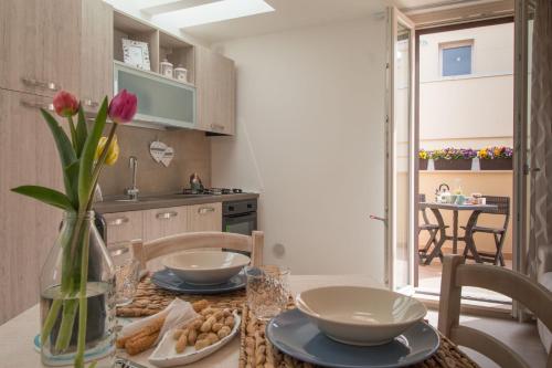 a kitchen with a table with a vase of flowers at Palazzo Rattazzi in Monopoli