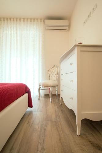 a bedroom with a dresser and a bed and a chair at Palazzo Rattazzi in Monopoli