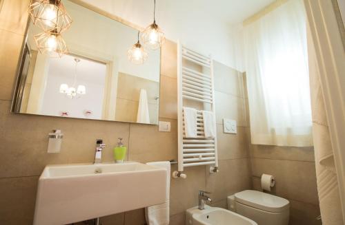 a bathroom with a sink and a toilet and a mirror at Palazzo Rattazzi in Monopoli