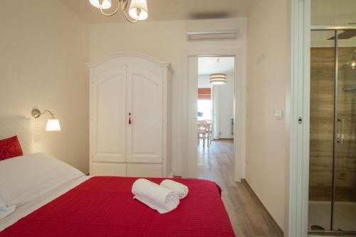 a bedroom with a red bed with two towels on it at Palazzo Rattazzi in Monopoli