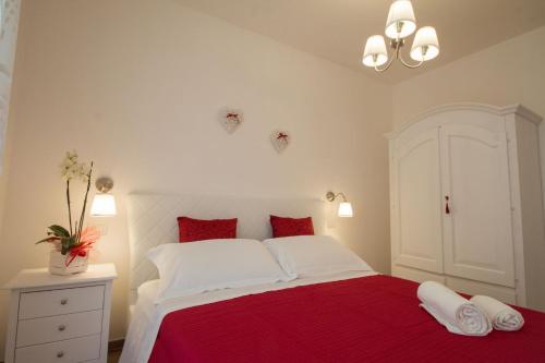 a bedroom with a red and white bed with red pillows at Palazzo Rattazzi in Monopoli