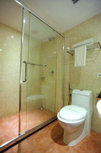 a bathroom with a toilet and a glass shower at Cochin Legacy in Cochin