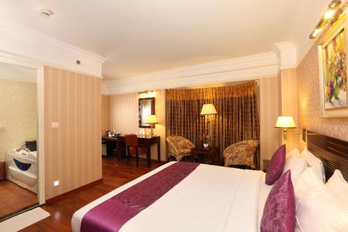 a hotel room with a bed and a desk at Cochin Legacy in Cochin