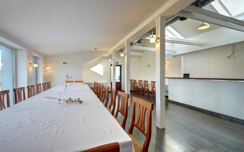 Una habitación grande con una mesa larga y sillas. en Aerohotel, en Vilna