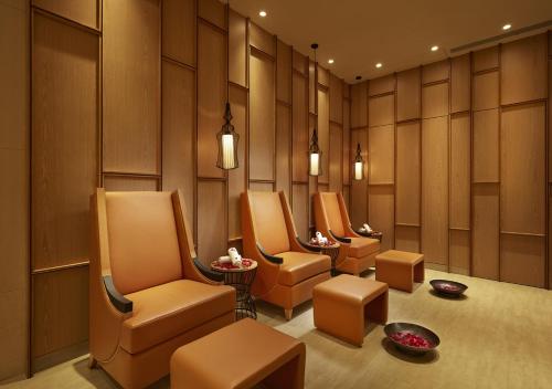 a waiting room with chairs and tables and lights at Radisson Mumbai Goregaon in Mumbai