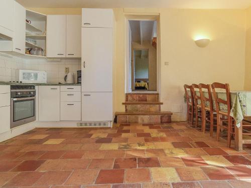 - une cuisine avec des placards blancs et un sol en briques dans l'établissement Mansion in Aquitaine with Private Pool, à Campsegret