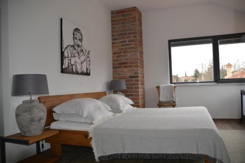 ein Schlafzimmer mit einem Bett und einer Ziegelwand in der Unterkunft Villa Kvarner in Krk