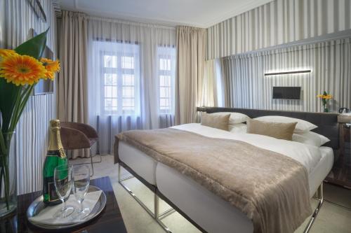 Schlafzimmer mit einem Bett und einem Tisch mit einer Flasche Champagner in der Unterkunft Clementin in Prag