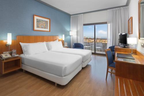 A bed or beds in a room at Elba Vecindario Aeropuerto Business & Convention Hotel