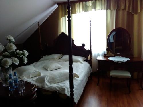 a bedroom with a four poster bed and a mirror at Zajazd Zagłoba in Widoma