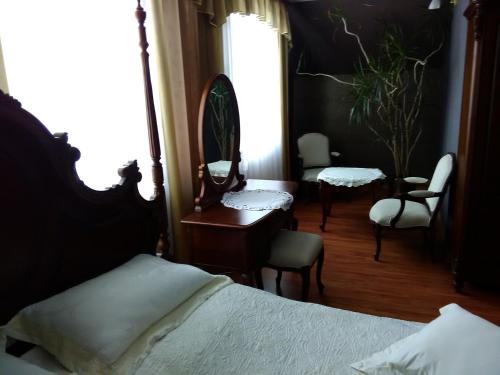 a bedroom with a bed and a mirror and chairs at Zajazd Zagłoba in Widoma