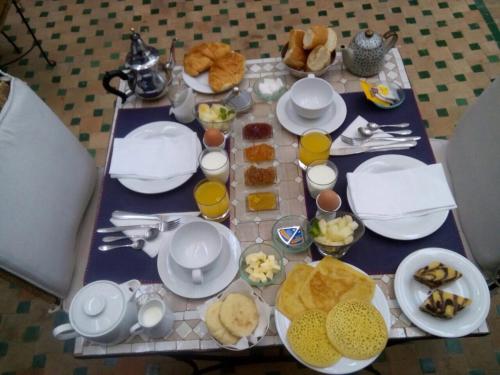a table with plates and cups of food on it at Riad Nafis in Marrakech