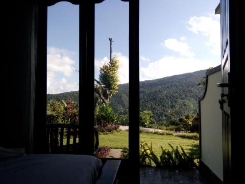 a room with a window with a view of a mountain at Aris Homestay and Warung Made in Munduk