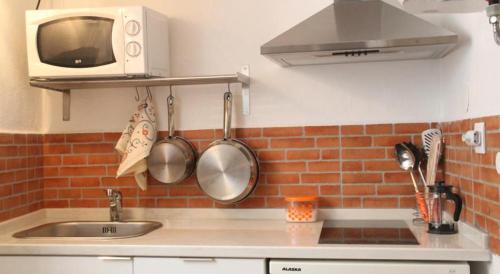 um balcão de cozinha com um lavatório e um micro-ondas em Lisbon Secret & Graca Apartment em Lisboa