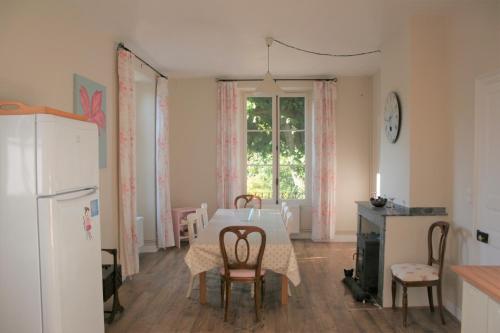 cocina con mesa, sillas y nevera en Maison Carrée - Chalabre, en Chalabre