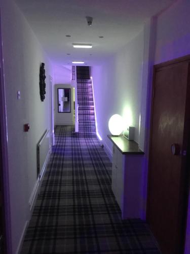 a hallway with purple lighting and a staircase in a house at The Danescourt in Blackpool