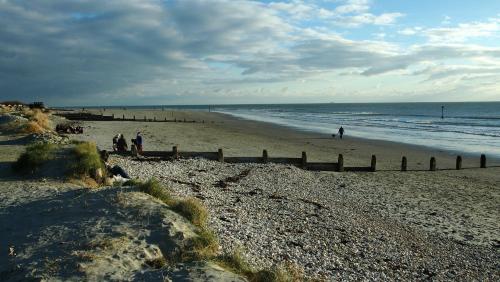 a group of people walking on the beach at Claron Lodge in West Wittering