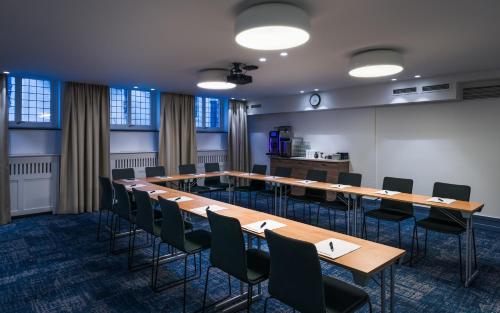 a conference room with a long table and chairs at Home Hotel Gabelshus in Oslo