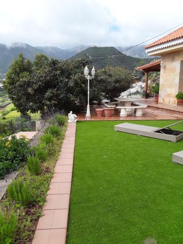 a garden with a green lawn and a house at Holiday Home Hemi in Valsequillo