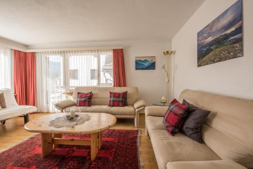 a living room with a couch and a table at Chesa Talvo, Samedan in Samedan