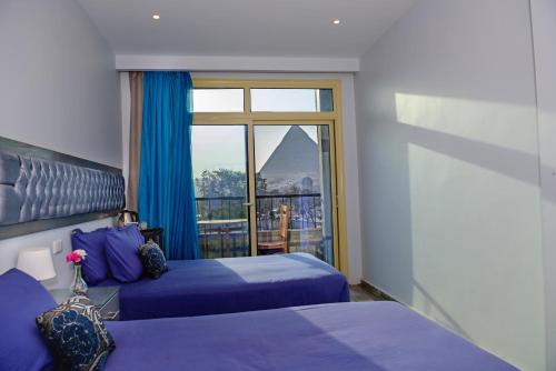 a bedroom with two beds and a view of a mountain at Pyramids View Inn in Cairo