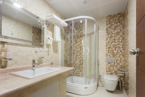 a bathroom with a sink and a shower and a toilet at Hotel Ritaj Alsahel in Yanbu
