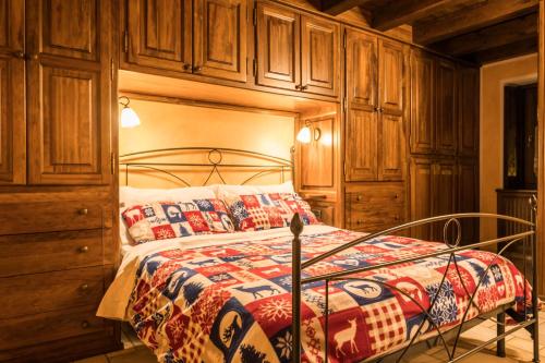 a bedroom with a bed with wooden cabinets at La Casetta di Francio & Marta in Aosta
